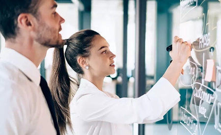 woman with man writing on board